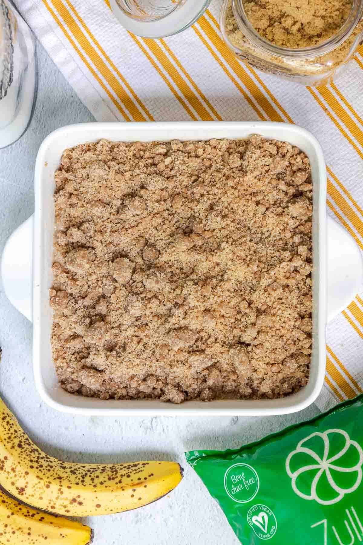 The crumble topping is sprinkled evenly over the cake batter for full coverage