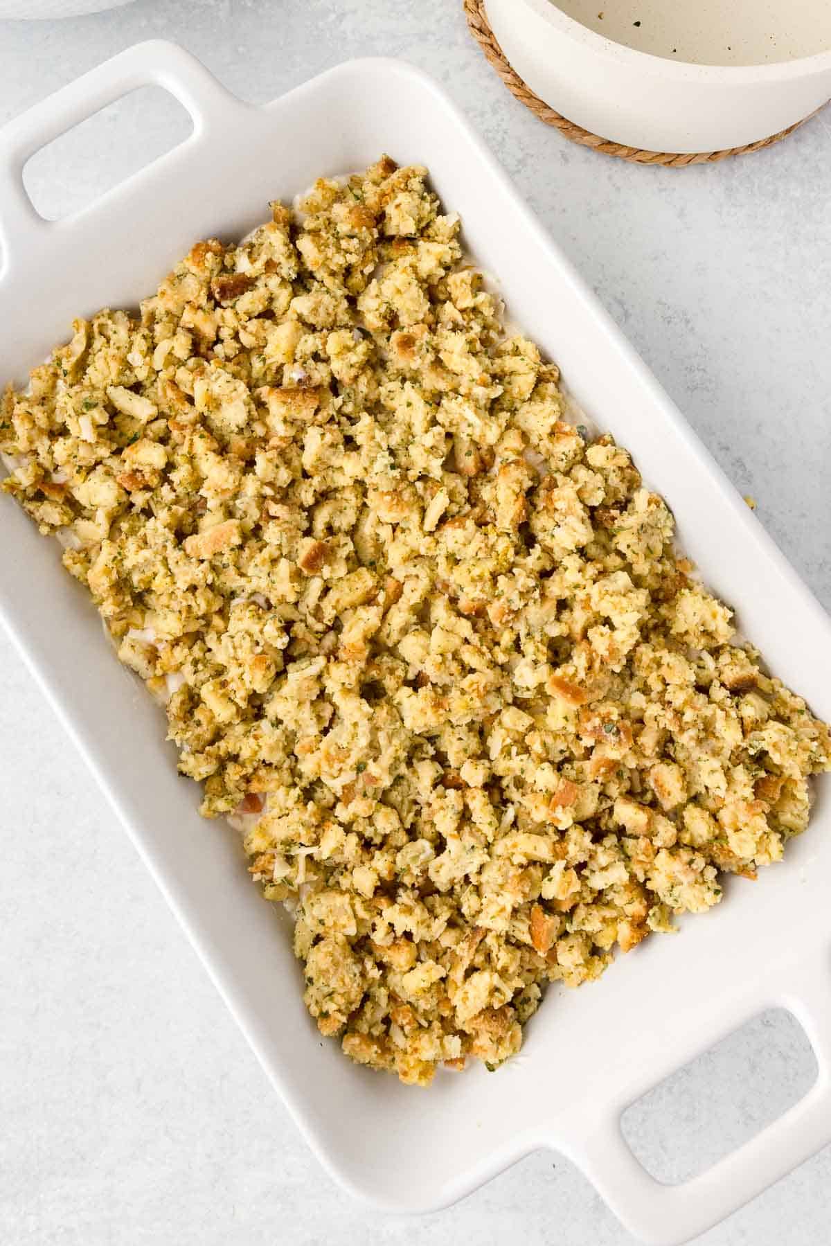Stuffing spread evenly over the chicken mixture in a casserole dish