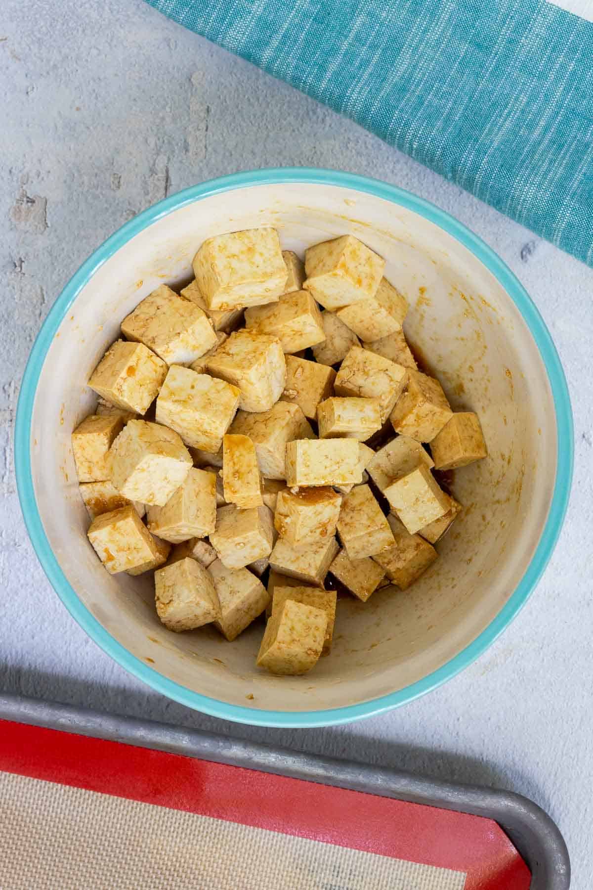Cubed tofu is tossed in the soy sauce marinade and well-coated.