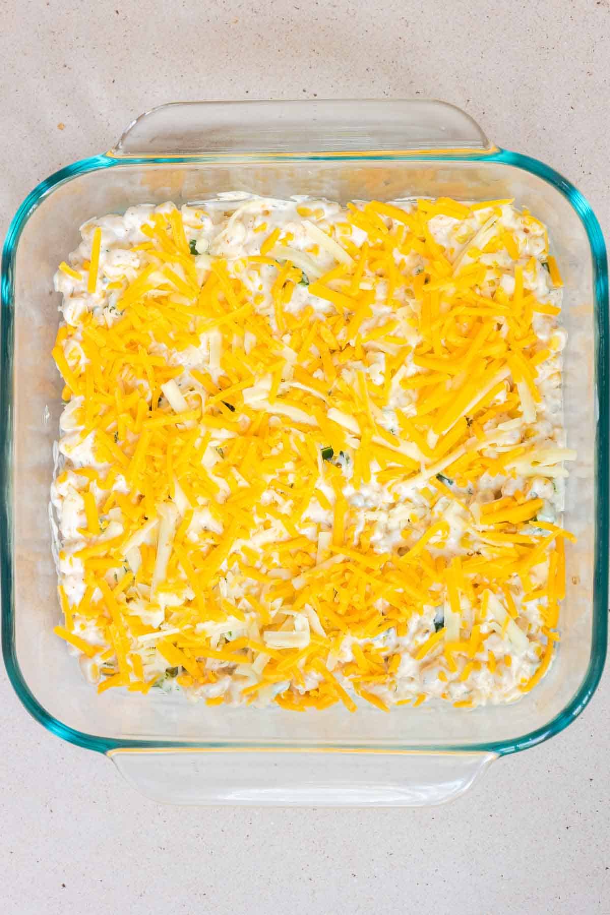 Shredded cheese is sprinkled evening over the top of the casserole.