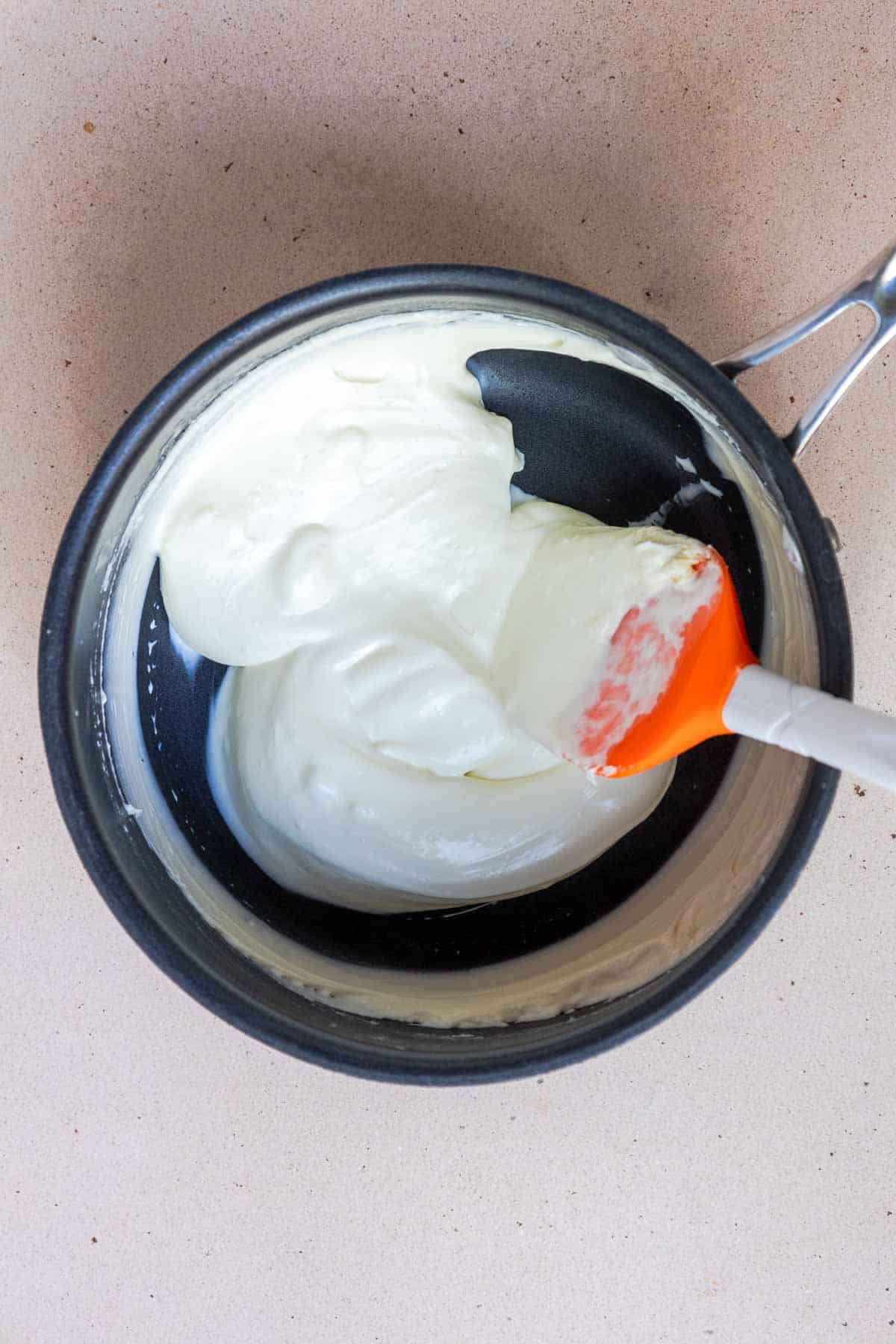 The heavy cream and cream cheese are heated in a medium saucepan until the cream cheese is melted and smooth.