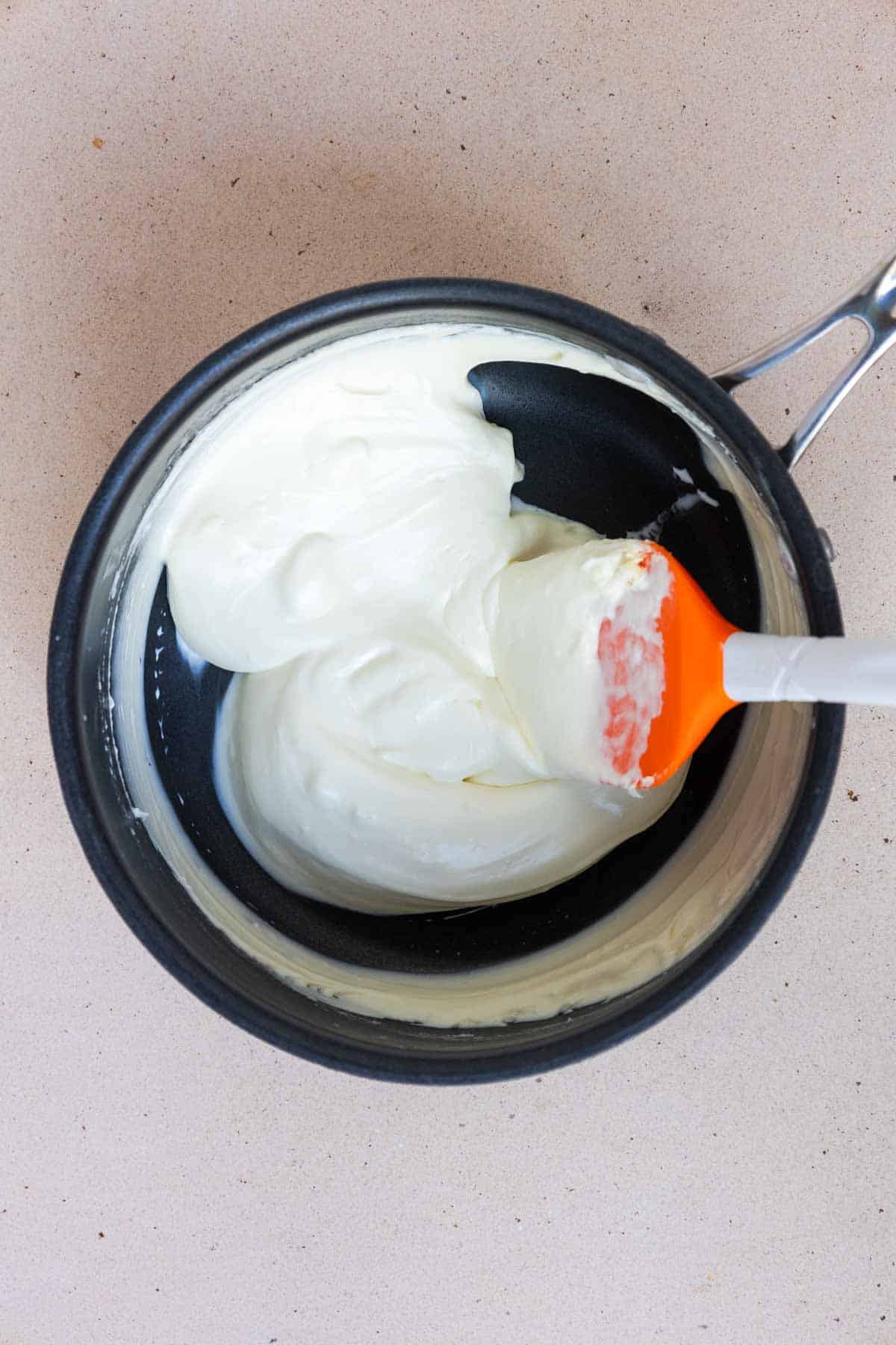 The cream cheese and heavy cream are warmed through in a medium saucepan until the cream cheese is melted and smooth.