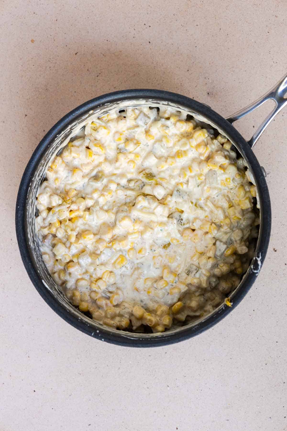 The corn casserole ingredients are mixed together in the saucepan until combined.