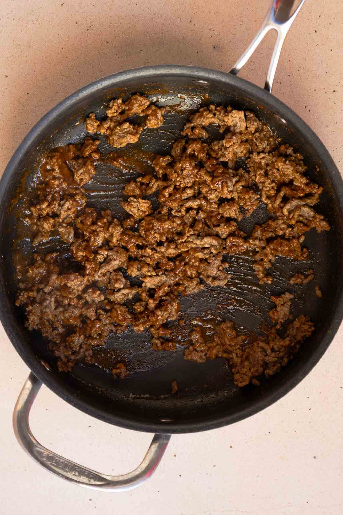 The ground beef is simmered in the taco seasoning and water until thickened.
