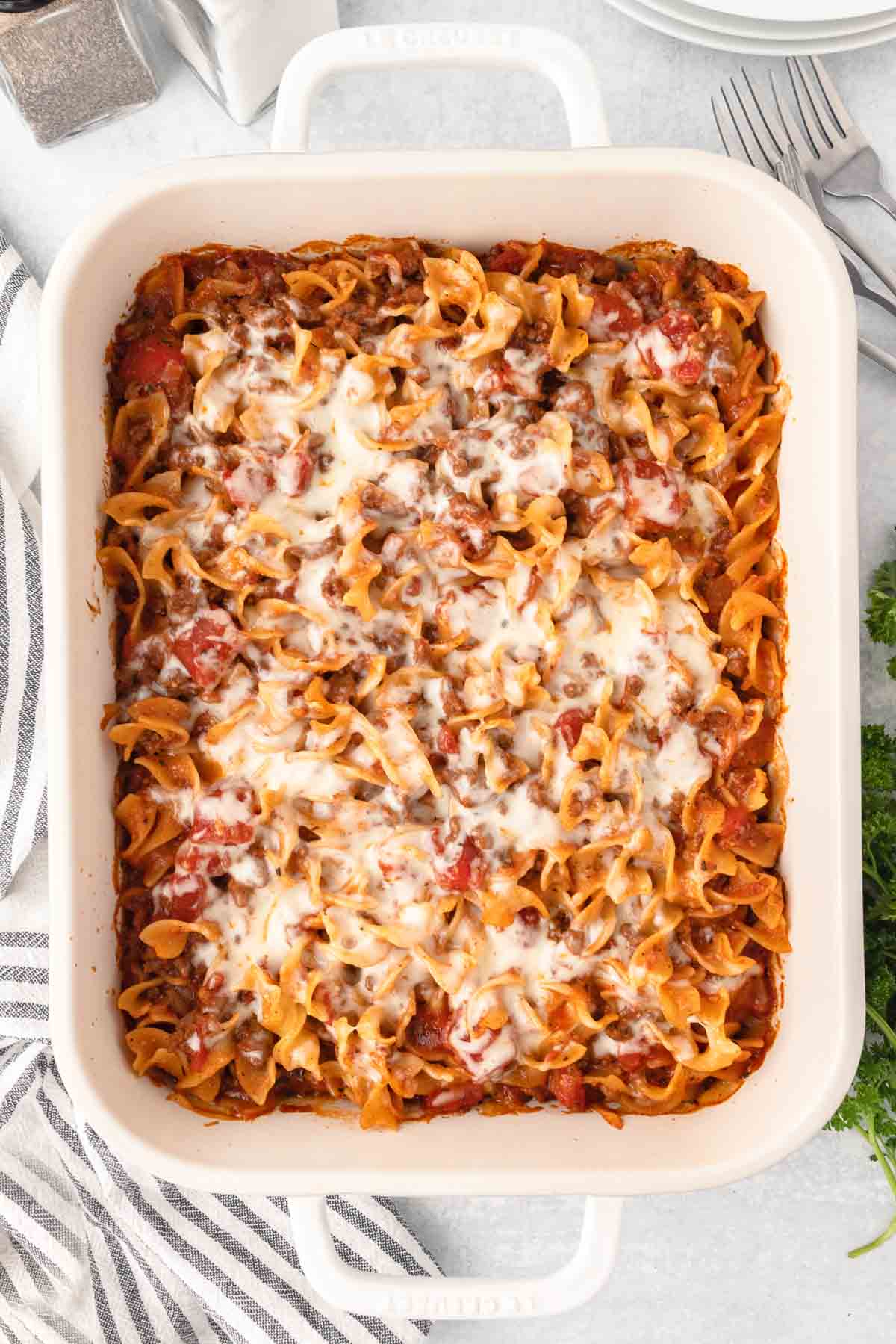 Baked mround beef noodle casserole with a layer of melted mozzarella on top.