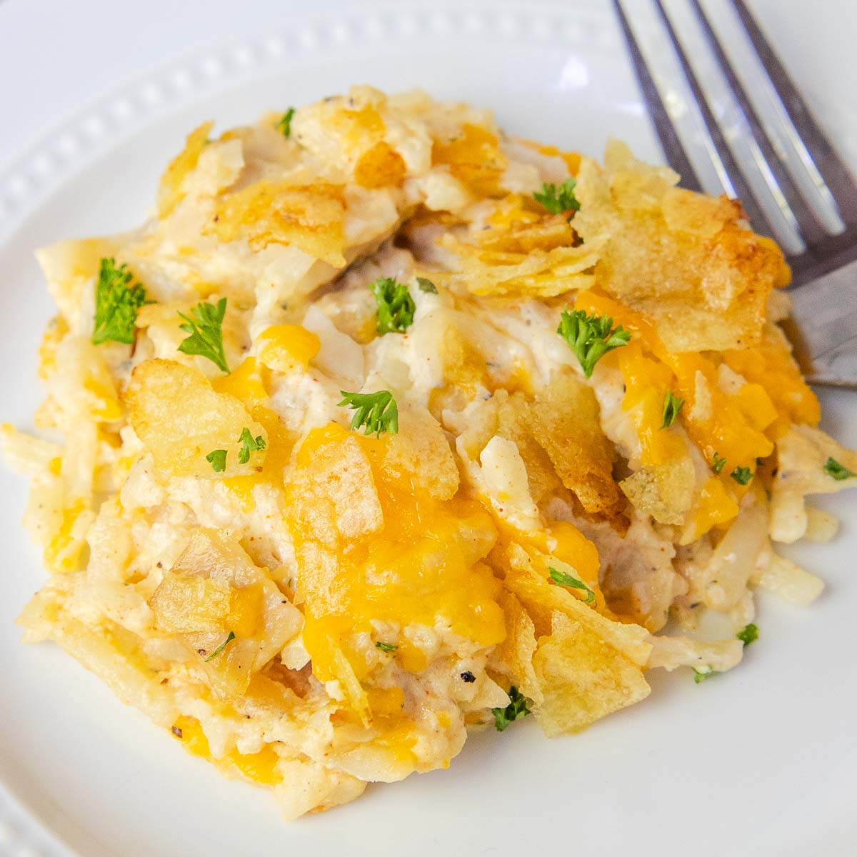 Chicken and hash brown casserole topped with crushed potato chips and cheese.