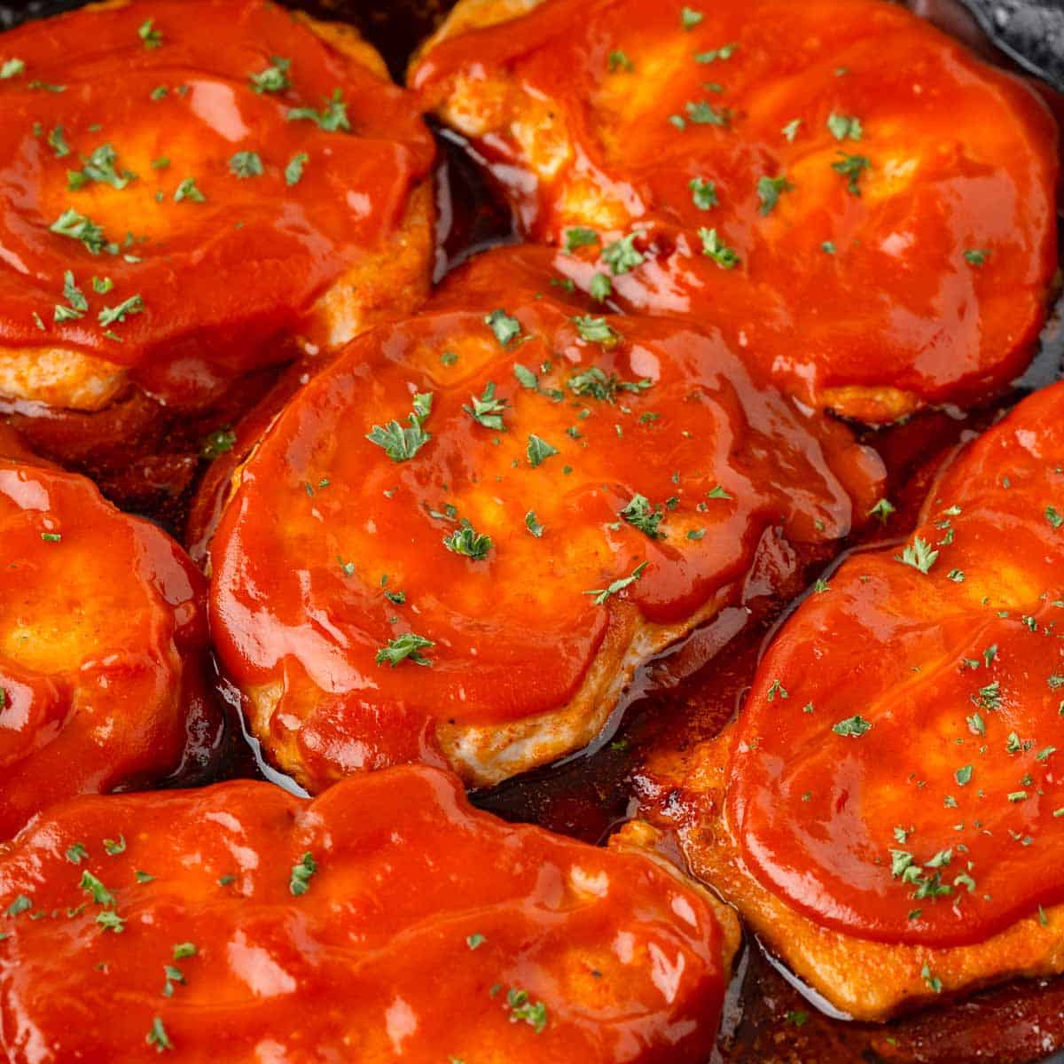 Boneless pork chops coated in bbq sauce in a large skillet