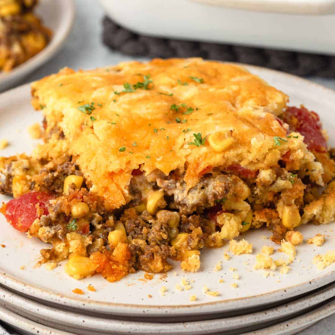 Ground Beef Jiffy Cornbread Casserole with layers of ground beef, corn, diced tomatoes, and cheese.