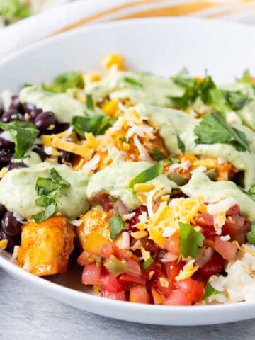 Southwest chicken rice bowls with pico de gallo, cilantro lime rice, black beans, corn, cheese, and avocado dressing