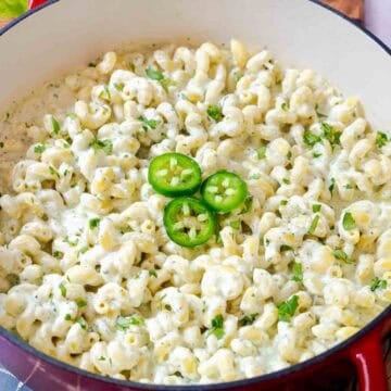 Creamy jalapeño ranch pasta topped with sliced jalapeños and cilantro in a large pot.