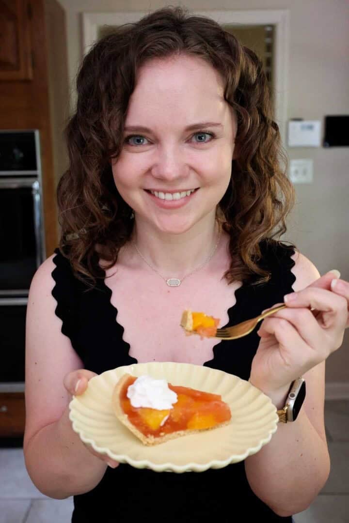 Kelsey Smith holding a plate with a slice of peach Jello pie.